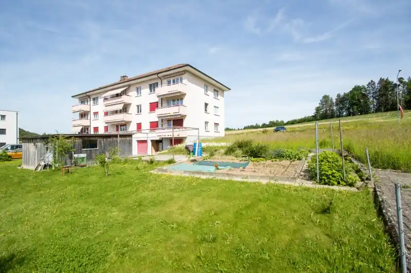 https://dr-gruenwald-immo.ch/wp-content/uploads/2026/07/Laendliches-Anwesen-mit-Mehrfamilienhaus-und-Garten.webp